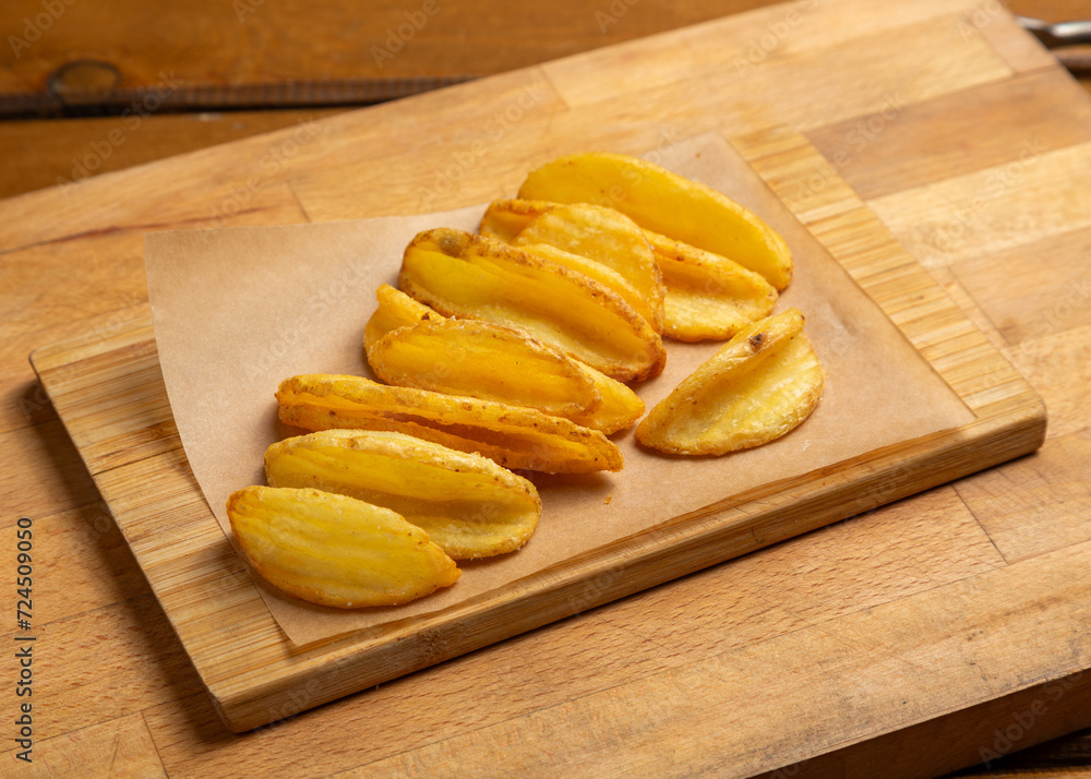 Potato slices fried on a wooden board Potato slices fried on a wooden board