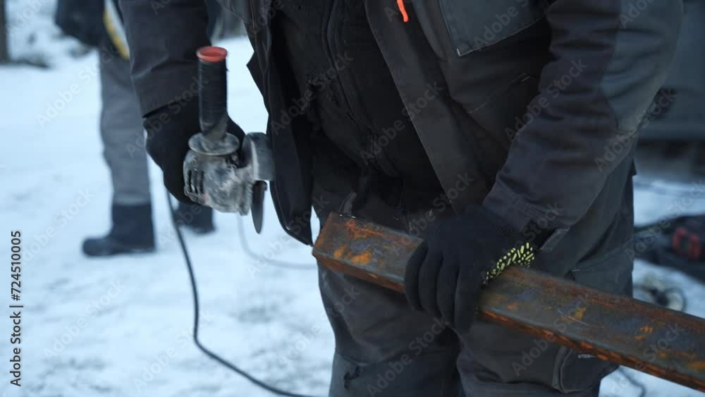 Worker cutting metal tube using an Angle Grinder. Bright sparks and flashes Worker cutting metal tube using an Angle Grinder. Bright sparks and flashes