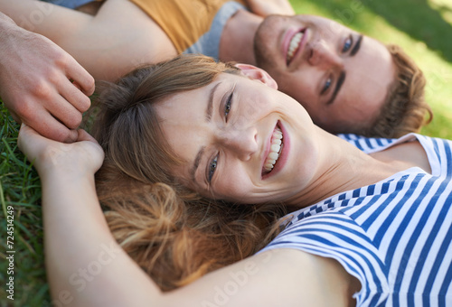Lawn, love and portrait of happy couple relax for summer sunshine, wellness or weekend break for outdoor leisure. Smile, care and face of boyfriend, girlfriend or people lying on grass pitch together