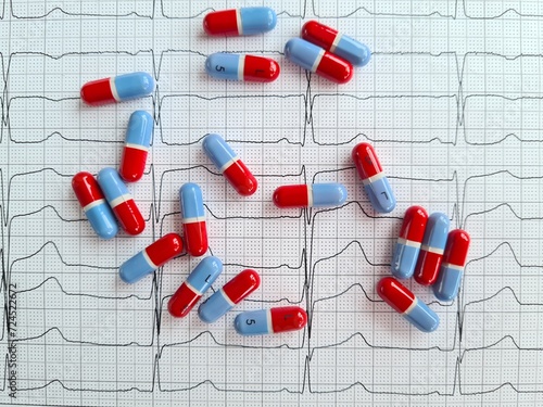 Red and Blue Pills Scattered on Heart Rate Monitor in Medical Illustration photo