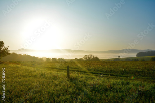 Early morning landscape with fog and sun