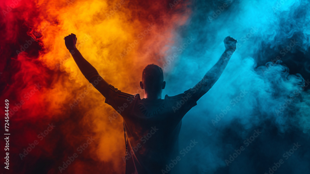 Cheering man rise arms against the background of red and blue smoke Cheering man rise arms against the background of red and blue smoke