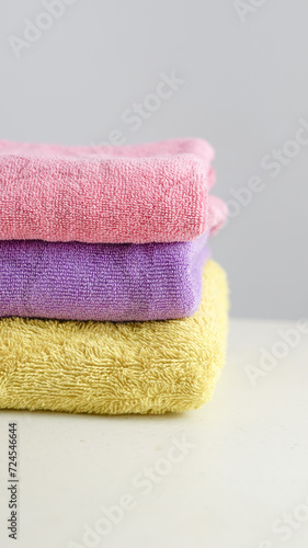 a pile of clean, folded and colored towels on a white background