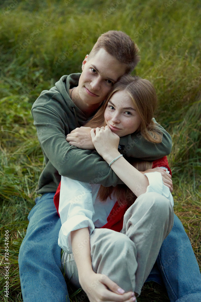 young teen couple laying on a grass on a field in september young teen couple laying on a grass on a field in september