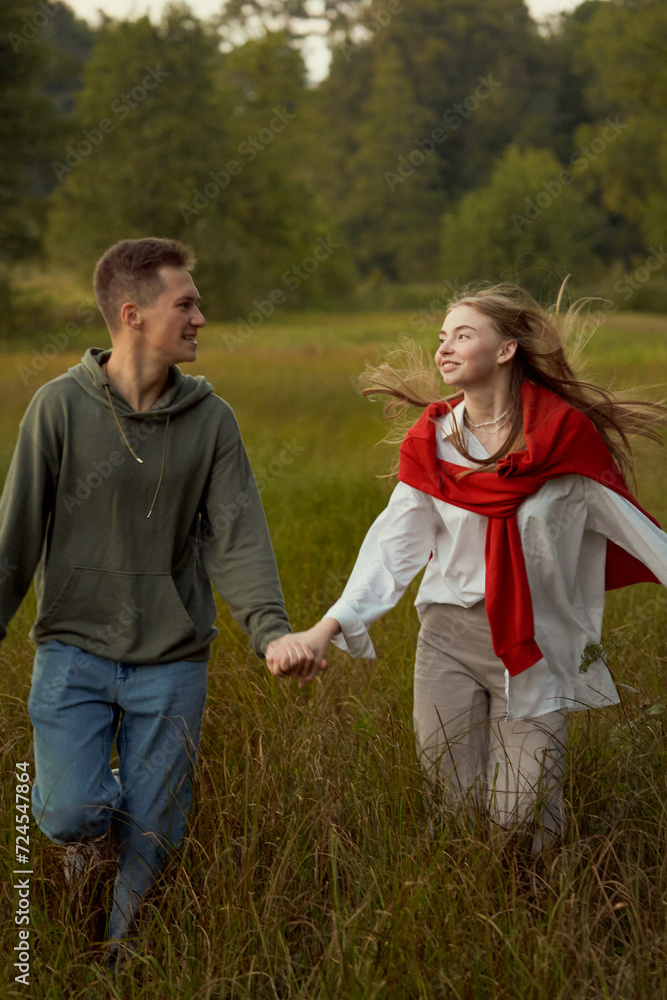 young teen couple run and play in field young teen couple run and play in field