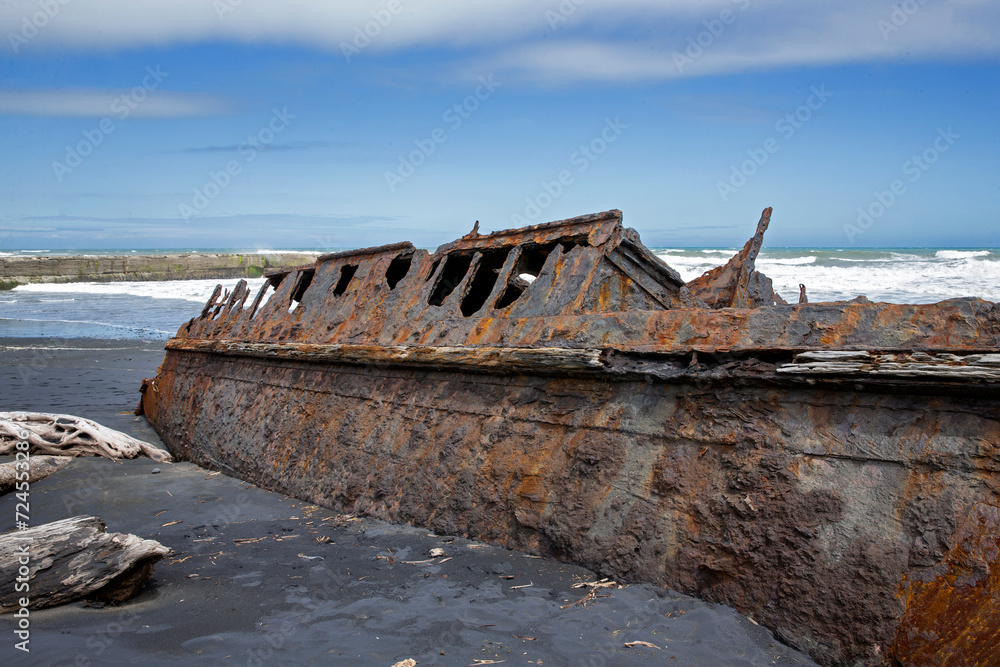 S.S. Waitangi shipwreck. Rusty shipwreck at Mana Bay New Zealand. Patea. Taranaki. Tasman Sea. Coast and Beach. Lava sand. S.S. Waitangi shipwreck. Rusty shipwreck at Mana Bay New Zealand. Patea. Taranaki. Tasman Sea. Coast and Beach. Lava sand.