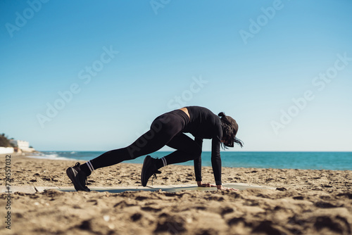 a girl doing exercises on the seashore in sportswear. fitness trainer girl doing exercise. There is space for writing text.
