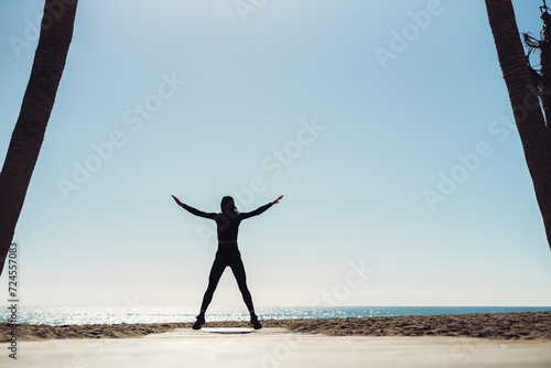 A young woman goes in for sports on the seashore. Women perform sports exercises. body silhouettes on the seashore. there is space for text