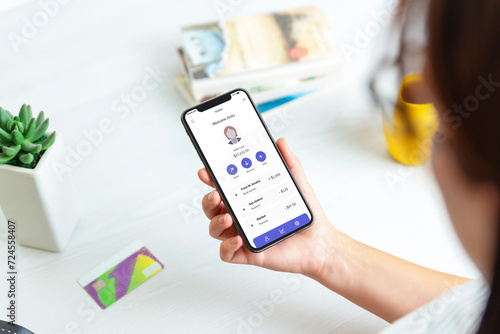 Woman adds credit card and account on a fintech service app, displayed on a modern smartphone. Featuring the account and a transaction list for seamless financial management photo
