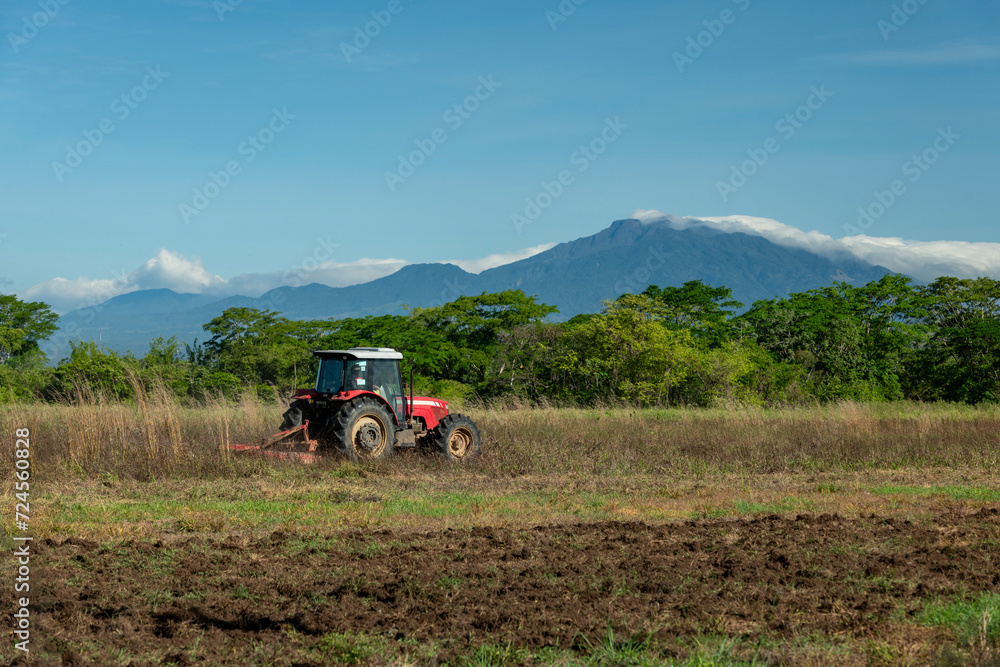 Blue sky over tractor plowing a field with Baru volcano in the background, Chiriqui, Panama, Central America - stock photo Blue sky over tractor plowing a field with Baru volcano in the background, Chiriqui, Panama, Central America - stock photo