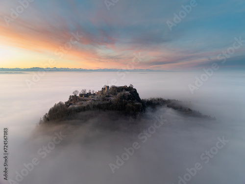 Luftbild vom Hegauvulkan Hohentwiel mit der oberen Festungsruine vor Sonnenaufgang, die bei einer Inversionswetterlage aus dem Nebel herausragt