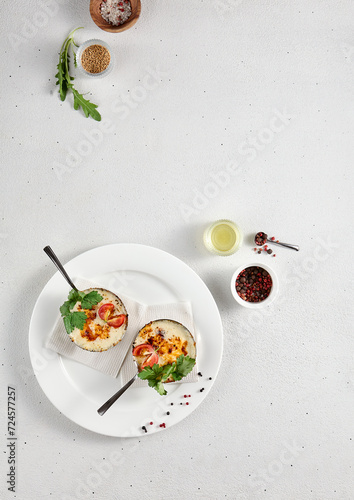 Elegant julienne with cheese and mushrooms in a white ceramic dish, top view with ample copy space for culinary branding