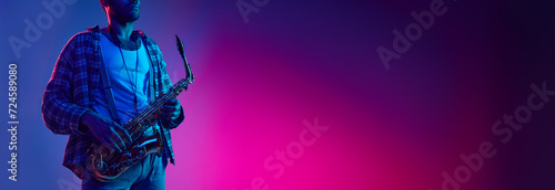 Jazz and blues melodies. African-American man holds saxophone against gradient blue background with negative space to insert text. Concept of classical musical instrument, concerts and festivals. Ad