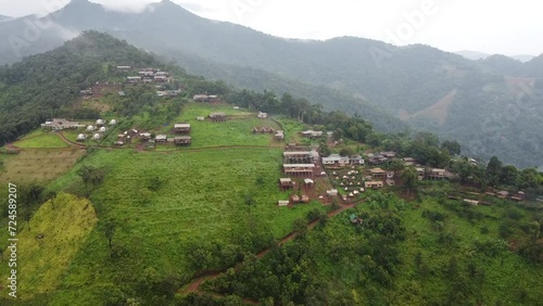 Aerial view of beautiful and rural villages. Village landscape in valley and green trees and mountain clouds in Thailand