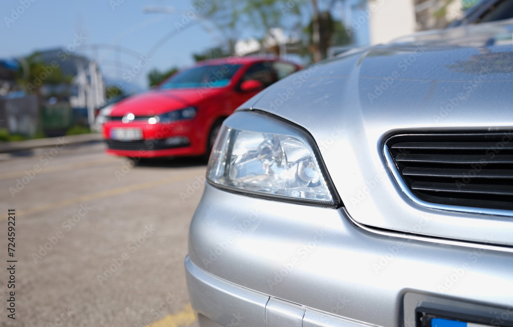 Closeup of clean headlights of silvery car in parking. Cars sale concept Closeup of clean headlights of silvery car in parking. Cars sale concept