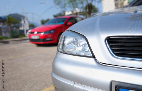 Closeup of clean headlights of silvery car in parking. Cars sale concept