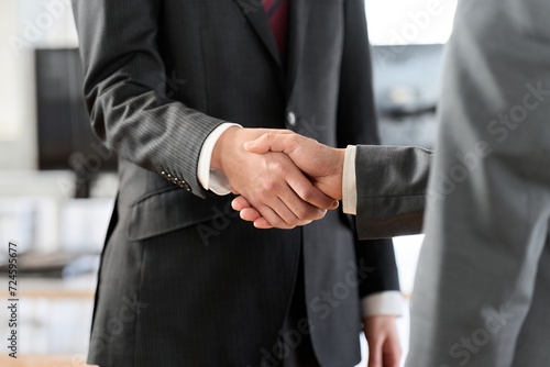 オフィスで握手をするアジア人ビジネスマン photo