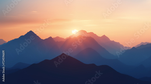 Silhouette of a mountain range against the early morning sky, the first light of sunrise peeking through the peaks
