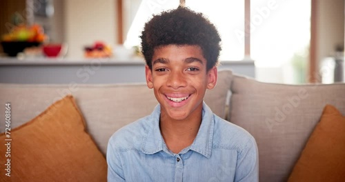 Boy, face and relaxing on couch on weekend, living room and happy or comfortable at home. Black male person, kid and smiling in portrait on vacation or holiday, laughing and humor or funny joke photo