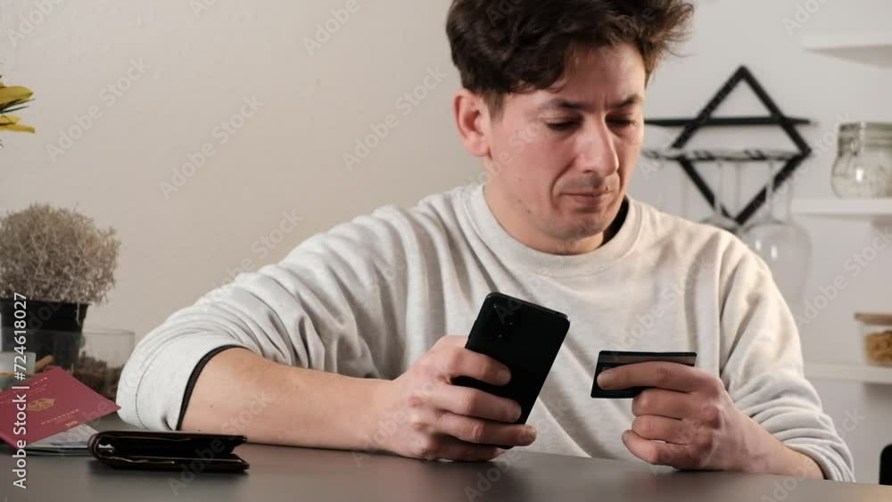 Man buying travel tickets on his phone with German passport on the table Man buying travel tickets on his phone with German passport on the table