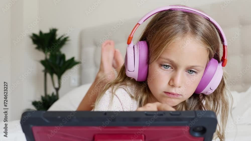 Cute little kid girl using digital tablet technology device lying on ...