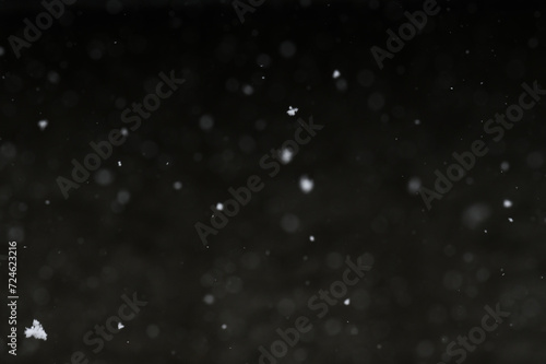 Bokeh of white snow on a black background. Snowfall - design element.