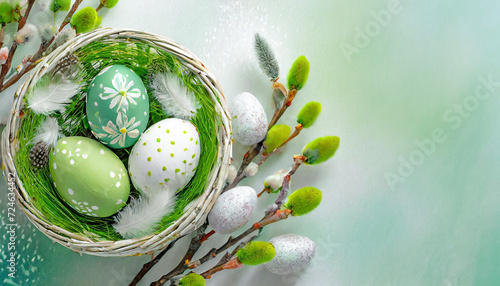 Green Easter background with Easter eggs in a basket and catkins photo