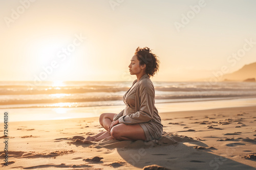A pregnant woman in a white outfit sits on the beach in a yoga pose. Dawn. Banner.