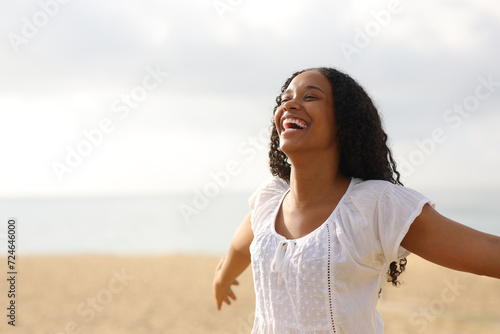 Photography Joyful black woman outstretching arms on the beach