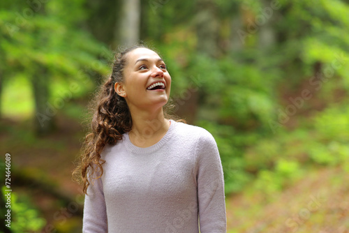 Foto Happy casual woman looking amazed in a forest