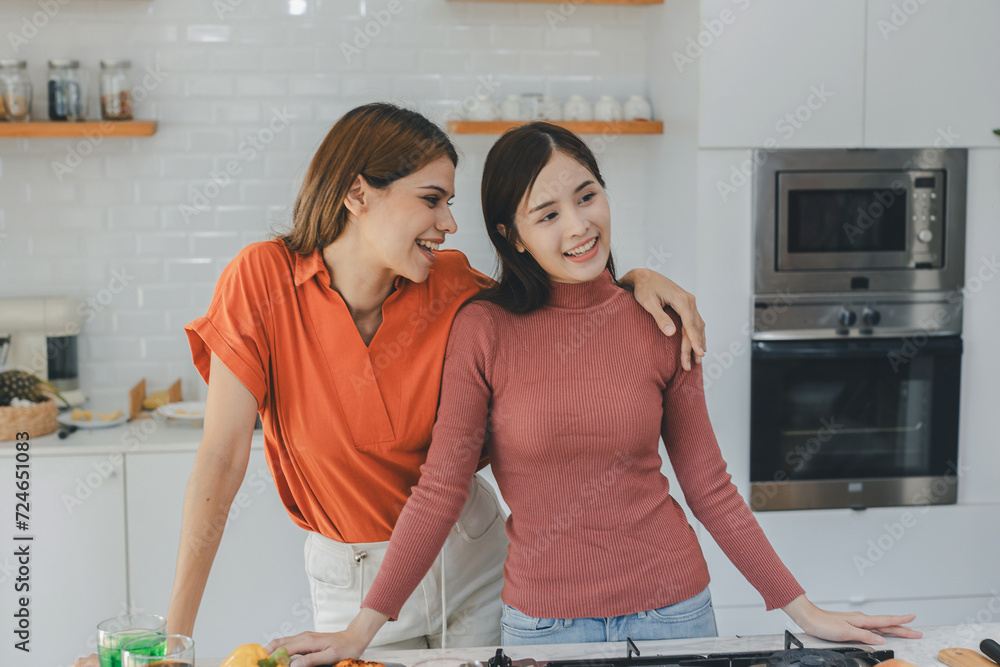 Multiethnic lesbian couple having embracing in kitchen room. black and white couple holding ring. positive African American and white lesbian couple hugging and looking at each other with tenderness Multiethnic lesbian couple having embracing in kitchen room. black and white couple holding ring. positive African American and white lesbian couple hugging and looking at each other with tenderness