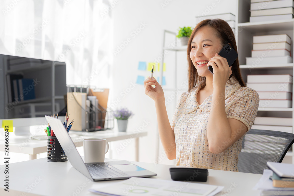 Attractive Asian woman standing talking on cell phone in office, professional entrepreneur standing and calling phone in office uniform. Smile and look confident. workplace background Attractive Asian woman standing talking on cell phone in office, professional entrepreneur standing and calling phone in office uniform. Smile and look confident. workplace background