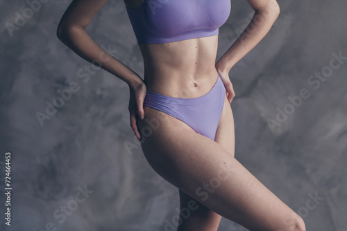 Fototapeta Naklejka Na Ścianę i Meble -  No filter cropped photo of slim woman touch thin waist after anti cellulite massage isolated on grey concrete wall background
