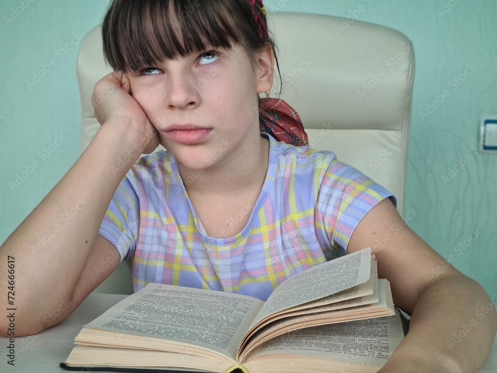 Tired schoolboy girl child bored student does not want to read a book Tired schoolboy girl child bored student does not want to read a book