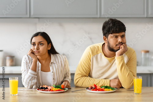 Unhappy young indian couple have breakfast together