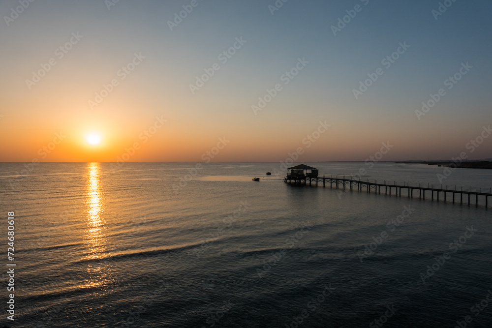 long jetty and small waves during a warm sunrise on vacation