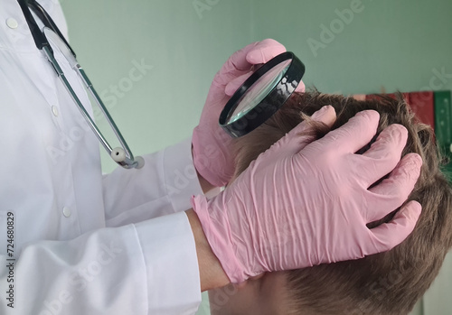 Trichologist holds magnifying glass checking hair of children and teenagers