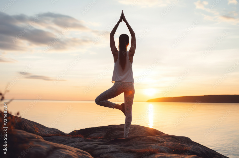 A girl meditates against the background of see and sunset. Tranquil Sunset Yoga - A Wellness and Mindfulness Journey.
