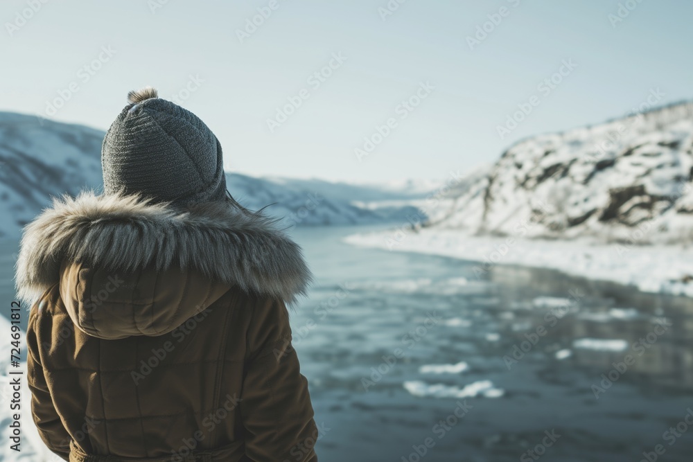 winter scene: person in a warm coat looking over an icy fjord winter scene: person in a warm coat looking over an icy fjord