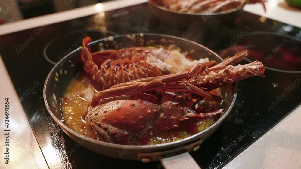 Close up of cooking spiny lobsters steaming on a frying pan on an electric stove. The most popular seafood dishes of the Caribbean cuisine Close up of cooking spiny lobsters steaming on a frying pan on an electric stove. The most popular seafood dishes of the Caribbean cuisine