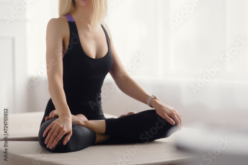 Fototapeta Naklejka Na Ścianę i Meble -  Closeup of calm fit young woman practicing breathing meditation, the image conveys the idea that fitness can be both rewarding and enjoyable,