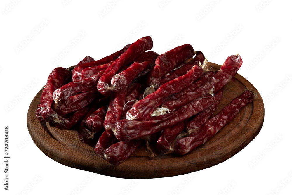 Fototapeta premium Smoked sausages (cabanos) on a wooden board close-up.