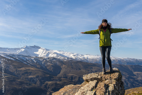 Woman Celebrating on Summit with Snowy Mountains, Granada