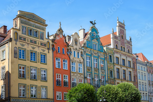 Facade of beautiful typical colorful houses on Dluga street (Dlugi Targ square) in old historical town centre on a sunny summer day, Gdansk, Poland photo