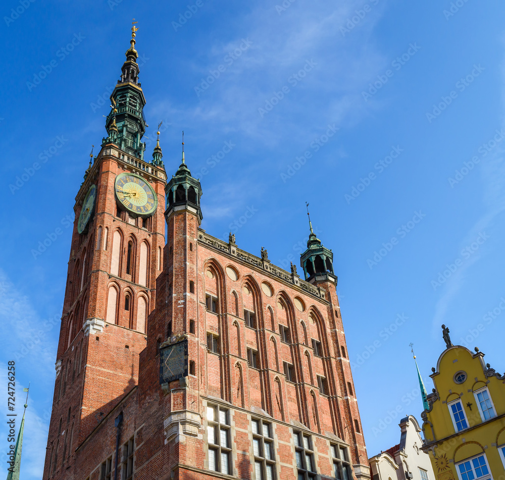 Obraz premium Beautiful architecture of the old town in Gdansk with city hall and Artus court, Poland. A walk through the city on a sunny summer day