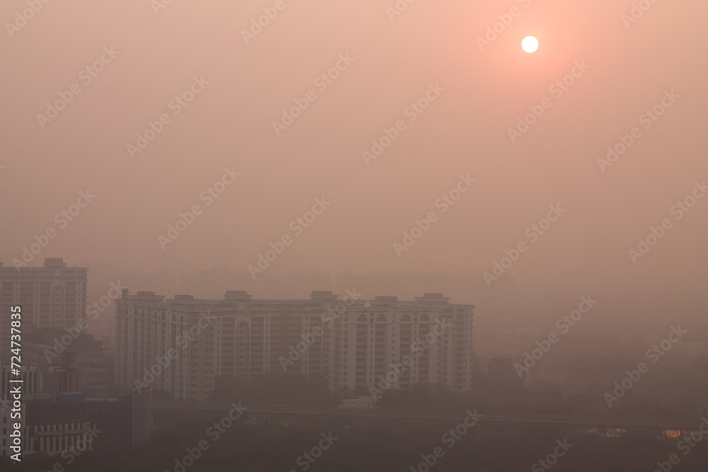 Foggy winter evening in Gurgaon,Haryana,India. Luxury residential apartments and commercial buildings with urban,modern architecture. Gurugram,Delhi NCR cityscape with dense fog at Sunset,