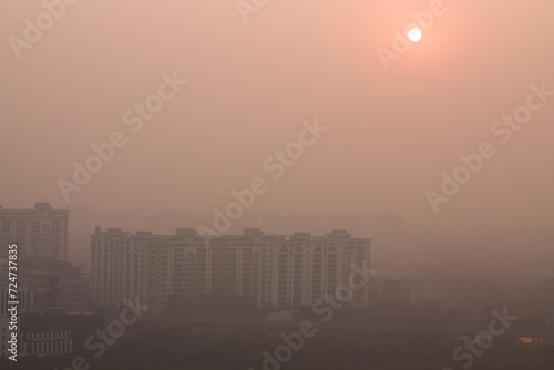 Foggy winter evening in Gurgaon Haryana India. Luxury residential apartments and commercial buildings with urban modern architecture. Gurugram Delhi NCR cityscape with dense fog at Sunset 