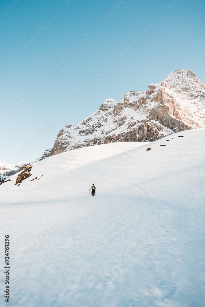  A man on ski alpine tour throught snowy Alps in Switzerland or Austria, Backcountry skier in Alps