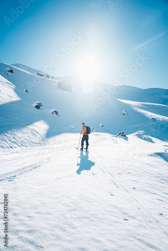 A man on ski alpine tour throught snowy Alps in Switzerland or Austria, Backcountry skier in Alps