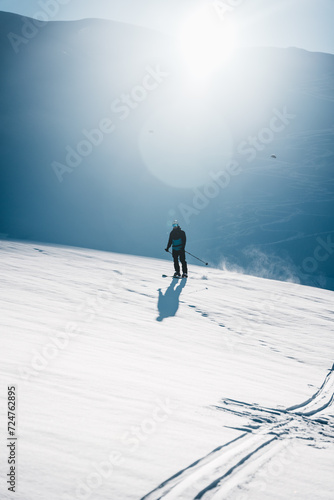 A man on ski alpine tour throught snowy Alps in Switzerland or Austria, Backcountry skier in Alps photo